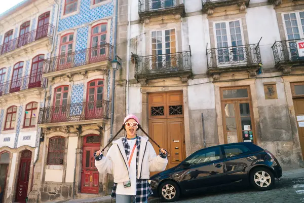 Şık bir birey canlı binaların önünde poz veriyor, şehir ortamında modern moda sergiliyor..