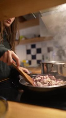 Yetenekli bir insan güzel bir mutfakta renkli sebzeler pişirir. Mutfak yaratıcılığını sergiler.