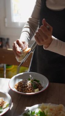 Yetenekli bir el, besleyici bir yemek için taze peyniri rendeliyor. Yemek pişirmeye ve lezzeti arttırmaya karşı gerçek bir tutku gösteriyor.