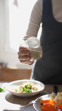 Tutkulu bir aşçı, güneş ışığıyla dolu parlak bir mutfakta sağlıklı bir yemek sezonu düzenler.