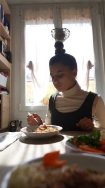 Genç bir kadının evde sağlıklı bir yemek yiyip mutluluğu vurguladığı huzurlu bir an.