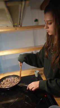 Olağanüstü odaklanmış bir birey, güzel bir modern mutfak ortamında lezzetli bir yemek hazırlar.