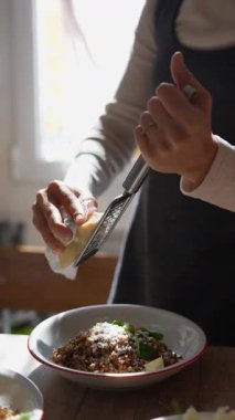 Yetenekli bir şef yemeğin üzerine taze rendelenmiş peynir serper. Yemekler için zevkini ve görsel çekiciliğini arttırır.