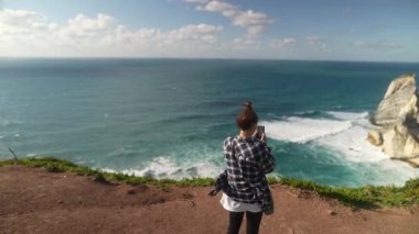 Bir birey muhteşem bir uçurumdan nefes kesici ve nefes kesici bir okyanus manzarası yakalar, gerçek güzellikleri gösterir.