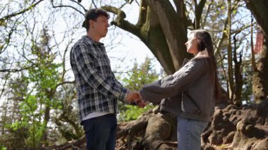 Genç bir çift, güzel ve doğal bir ortamda el ele tutuşurken son derece içten ve anlamlı bir anı paylaşır.