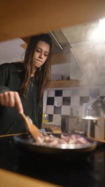 Sıcak bir mutfakta büyük bir hünerle yemek pişiren bir insan mutfak yaratıcılığını ve sanata olan derin tutkusunu sergiliyor.