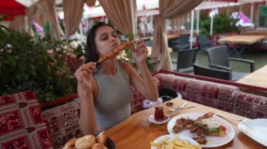 Canlı bir açık hava yemek ortamında ızgara şiş ve lezzetli ısırıkların tadını çıkarmanın zevkini çıkarıyorum.