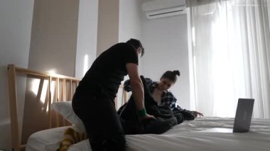 Sıcak bir yatakta neşeli bir etkileşim iki yakın arkadaş arasındaki derin dostluğu vurgular.