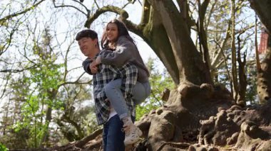 Neşeli bir çift, neşeli bir şekilde dışarıda güneşli bir günün tadını çıkarıyor, birlikte gülüyor, gülüyor ve şefkat gösteriyorlar.