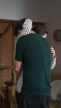 Sıcak ve sevgi dolu bir kucaklaşmanın tadını çıkaran bir çift, sıcak bir ev atmosferinde harika bir şekilde bağlarını ve aşklarını sergiliyorlar.