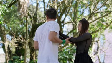 Doğanın bereketli yeşilliği arasında zarif hareketler sergileyen güzel bir koreografi dans sahnesi.