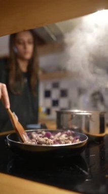 Genç bir aşçı sıcak bir mutfakta güzel bir dizi yemek hazırlar ve ev yemeğinin özünü yakalar.