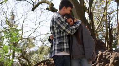 Genç bir çift, güzel bir ağacın altında sevgi ve bağla dolu hassas, samimi bir anın tadını çıkarır.