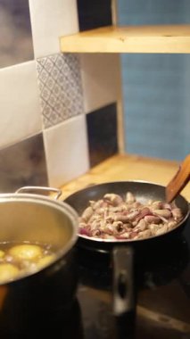 Lezzetli malzemeler ahşap bir kaşıkla kızartma tavasında soteleniyor.