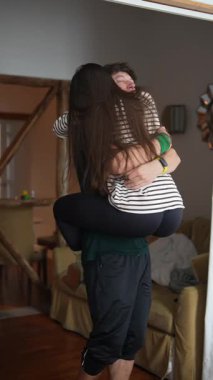 Neşeli bir çift sıcak bir ev ortamında sevgiyle kucaklaşır. Saf mutluluk ve derin bir bağ yayarlar.