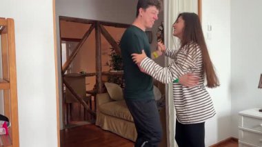 Sevecen bir çift güzel dekore edilmiş ve davetkar bir oturma odasında sevgi dolu bir kucaklaşmayı paylaşıyor.