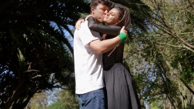 Bir çift, doğada hassas bir anı paylaşıyor. Palmiyelerle çevrili, derin bağlarının tadını çıkarıyorlar.