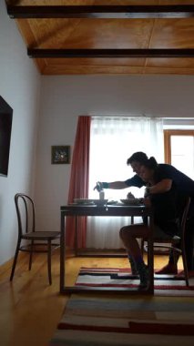 Sıcak ve davetkar bir ortamda bir masada oturmuş lezzetli bir yemeğin tadını çıkarmaya odaklanmış bir birey.