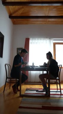 İki genç insan, sıcak ve davetkar bir ortamda birlikte yemek yemekten zevk alıyorlar.