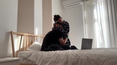 Sevecen bir çift, parlak, modern ve şık bir yatak odası ortamında hassas ve samimi bir anı paylaşıyor.