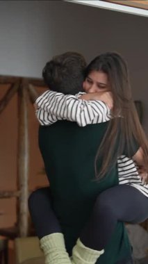 Sevgi dolu bir çiftin paylaştığı neşeli bir an. Birbirlerini kucaklıyor ve derin bağlarını sıcak bir ortamda sergiliyorlar.