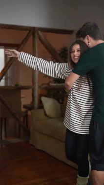 Neşeli bir çift evlerinde neşeli bir şekilde dans ediyor, derin neşe ve bağlarını sergiliyorlar.