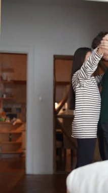 Bir çiftin evde neşeyle dans ettiği, birlikte derin bir sevgi ve mutluluk gösteren tatlı ve yürek ısıtan bir an.