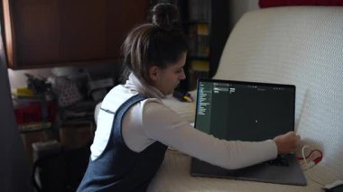 Odaklanmış bir insan şık bir dizüstü bilgisayarla etkileşime girer, rahat ve davetkar bir ortamda kesme aletini sergiler.