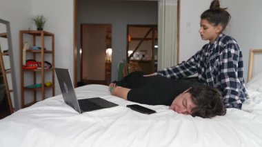 İki arkadaş yatağında rahat bir anın tadını çıkarıyorlar. Yanında da bir laptop var.