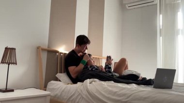 Sevgi dolu bir çift, güzel, modern, güneşli bir yatak odasında samimi ve sevgi dolu anların tadını çıkarıyor.