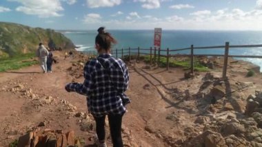 Doğanın ve yeşilliğin çarpıcı manzarasıyla çevrili güzel sahil boyunca manzaralı bir yürüyüşün tadını çıkarıyorum.