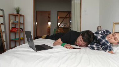 Sevgi dolu bir çift, rahat bir ortamda laptoplarıyla birlikte keyifli bir anın tadını çıkarıyor.