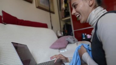 Odaklanmış genç bir kadın iki farklı dizüstü bilgisayarla birden fazla iş yapıyor. Bu da ofis verimliliğini gösteriyor.