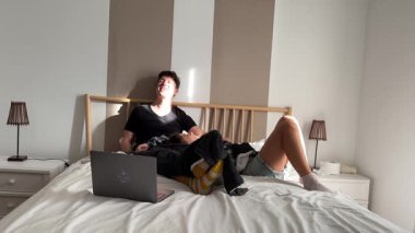 Bir insan rahat bir şekilde rahat bir yatakta dizüstü bilgisayarla uzanır, rahat ve huzurlu bir anın tadını çıkarır.