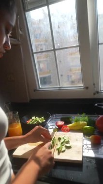 Güneşli bir mutfakta, yetenekli bir şef taze malzemeler hazırlar, aşçılık tutkularını ve uzmanlıklarını gözler önüne serer.