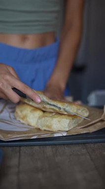 Bir insan taze pişmiş ekmek hazırlar ve servis eder. Lezzetli bir ev yapımı pişirme işlemi sunar..