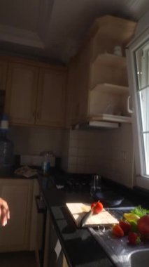 Doğal ışıkla aydınlatılmış taze ürünlerle sağlıklı gıda hazırlığını ön plana çıkaran parlak bir mutfak sahnesi.