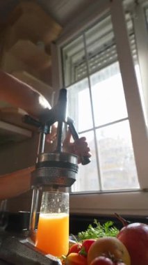 Canlı ve canlı bir sahne. Evde taze, lezzetli portakal suyu yapmanın zevkli sürecini gözler önüne seriyor.