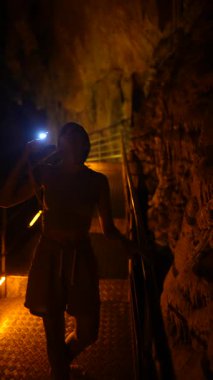 Bir insan karanlık bir mağarayı kazarken nefes kesici ve büyüleyici mağara şekillerini ustalıkla aydınlatır.