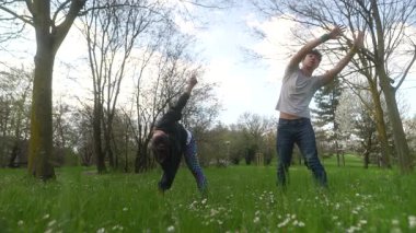 Neşeli bir çift, neşeli atletizmlerini yemyeşil çimlerle dolu canlı ve canlı bir ortamda sergiliyor.