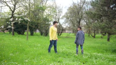 İki genç yetişkin, bu güzel bahar sezonunda canlı ve güzel yeşil parkta eğleniyorlar.