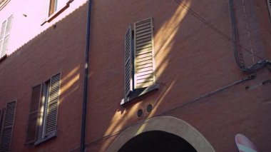 Kırsal tuğla duvarlarda dans eden güzel bir ışık ve gölge gösterisi büyüleyici bir atmosfer yaratıyor.