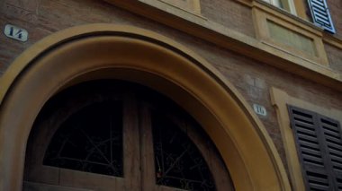 Zarif ve tarihi bir kapı aralığı büyüleyici ahşap panjurların yanında güzel dekoratif bir kemer sergiliyor.