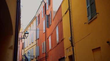 Renkli binalar ve klasik sokak lambalarıyla dolu canlı bir sokak aralığı keşfedin..