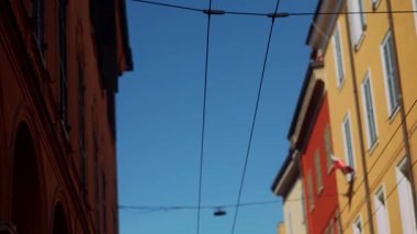 Göz kamaştırıcı ve pitoresk bir sokak manzarası berrak mavi bir gökyüzü zeminine karşı canlı ve renkli binalar sergiliyor.