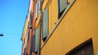 Açık mavi gökyüzünün altında duran renkli binalarla karakterize edilmiş çarpıcı, canlı mimariyi keşfedin.