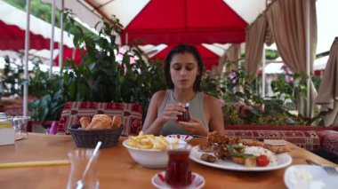 Lezzetli bir yemeğin yanında hayat dolu ve canlı bir restoranda çay içmek.