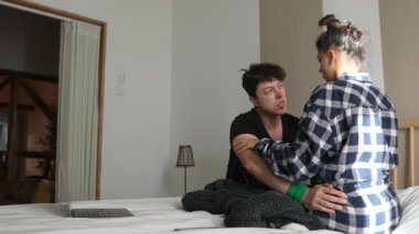 Bir çift, sıcak yataklarında rahat bir şekilde otururken derin ve duygusal bir sohbette duygularını paylaşıyor.