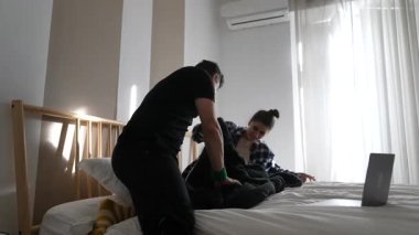 Sıcak bir yatakta neşeli bir etkileşim iki yakın arkadaş arasındaki derin dostluğu vurgular.