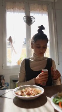 Güneşli bir mutfakta, bir kadın yemeğini ustalıkla hazırlar, canlı yemekler ve rahat bir atmosfer sunar.